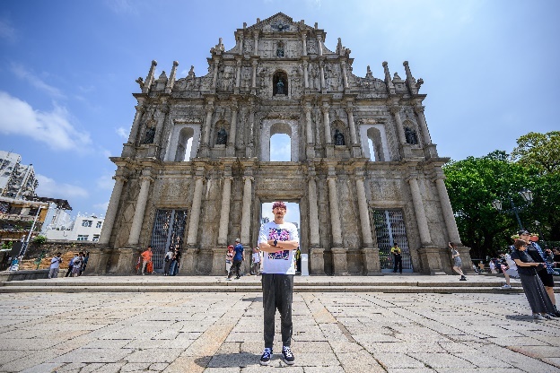 A person standing in front of Ruins of St. Paul'sDescription automatically generated