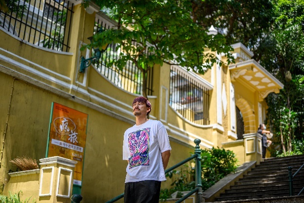 A person standing on stairs outside a buildingDescription automatically generated